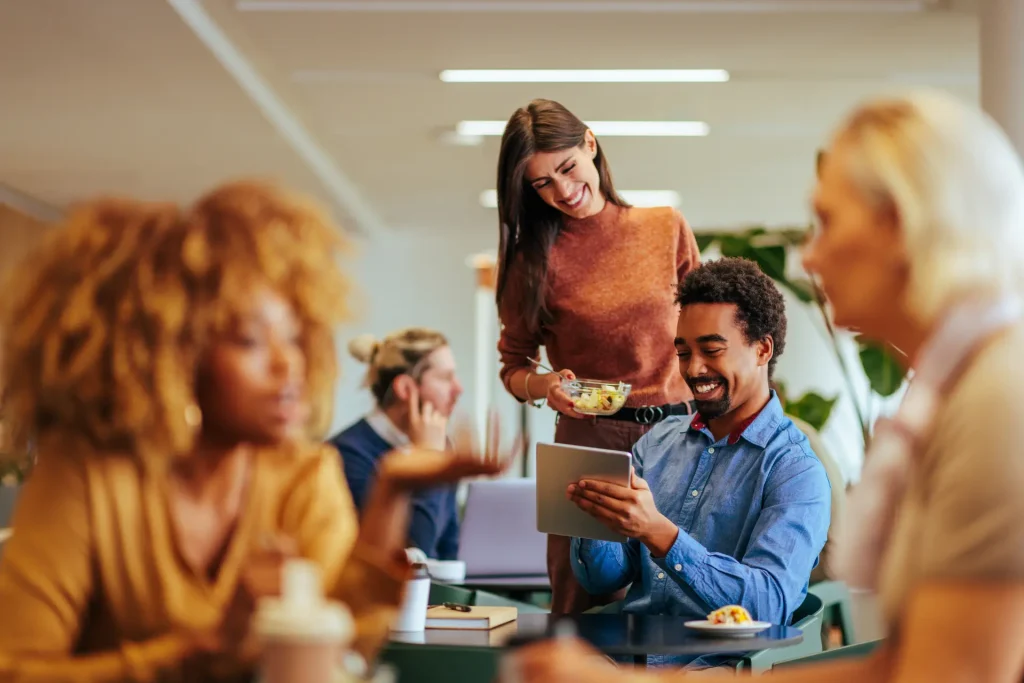 Diverse group of professionals networking and socializing in the dedicated breakout and cafe area at Ocean House, Portsmouth.